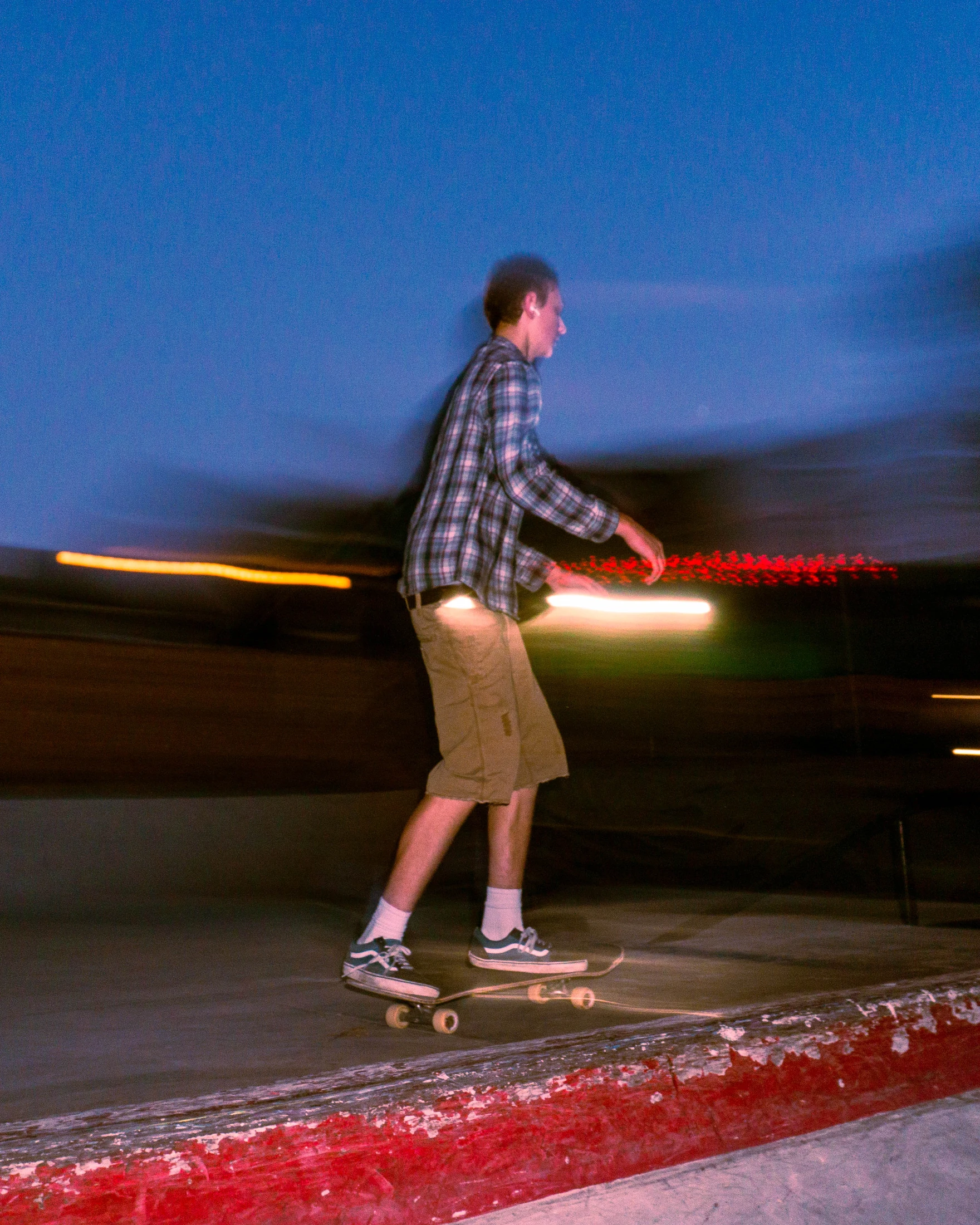 A skateboarder tracing the light at dusk